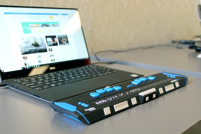 A refreshable braille display connected to a laptop computer.